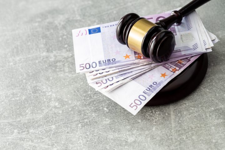 Euro banknotes and judge gavel on old table.